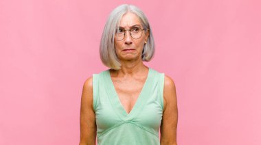 Orta yaşlı, güzel bir kadın gururlu, kibirli, mutlu, şaşırmış ve tatmin olmuş görünüyor.