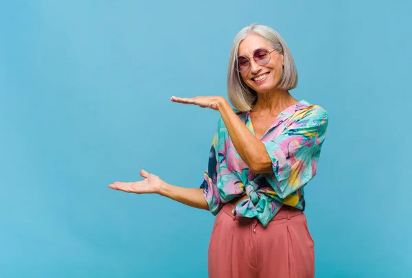 Mujer Cool Mediana Edad Sosteniendo Objeto Con Ambas Manos Espacio —  Fotos de Stock