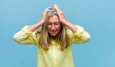 Orta yaşlı, güzel bir kadın. Kışkırtıcı, agresif ve müstehcen. İsyankar bir tavırla orta parmağını hareket ettiriyor.