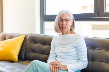 middle age pretty woman feeling puzzled and confused, with a dumb, stunned expression looking at something unexpected