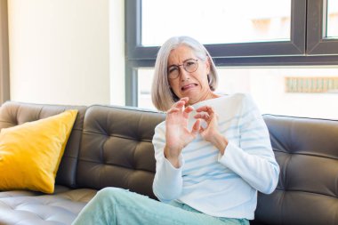 Orta yaşlı, güzel bir kadın tiksinmiş ve midesi bulanıyor. Pis kokan ya da kokan bir şeyden kaçıyor. İğrenç diyor.