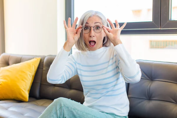 Mujer Bonita Mediana Edad Sintiéndose Sorprendida Sorprendida Sorprendida Sosteniendo Gafas —  Fotos de Stock