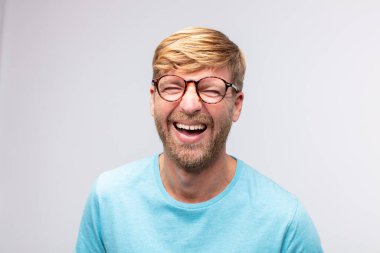 Genç sarışın adam mutlu ve gülümsüyor. tatmin edici ifade