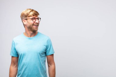 Genç sarışın adam mutlu ve gülümsüyor. tatmin edici ifade