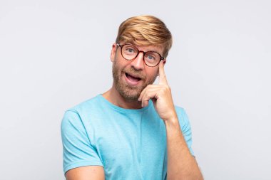 Genç sarışın adam düşünme ya da şüphe dolu bir ifade