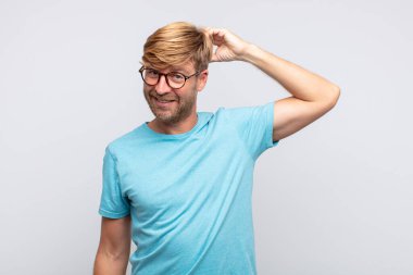 Genç sarışın adam düşünme ya da şüphe dolu bir ifade