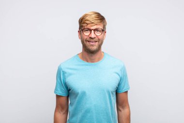 Genç sarışın adam poz veriyor.