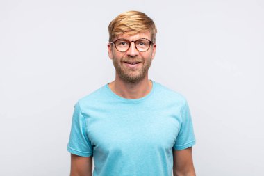 Genç sarışın adam poz veriyor.