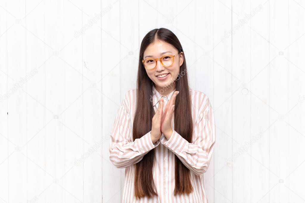asian young woman feeling happy and successful, smiling and clapping hands, saying congratulations with an applause