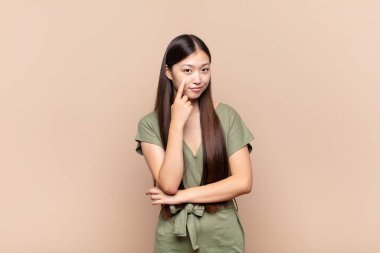 Asyalı genç kadın sana göz kulak oluyor, güvenmiyor, izliyor, tetikte ve tetikte.