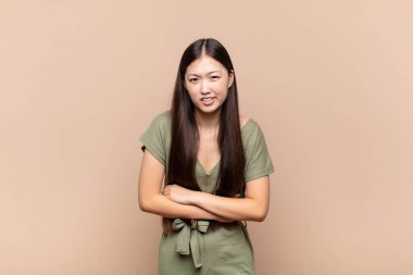 Asyalı genç kadın endişeli, hasta, hasta ve mutsuz hissediyor. Ağrılı bir mide ağrısı ya da grip geçiriyor.