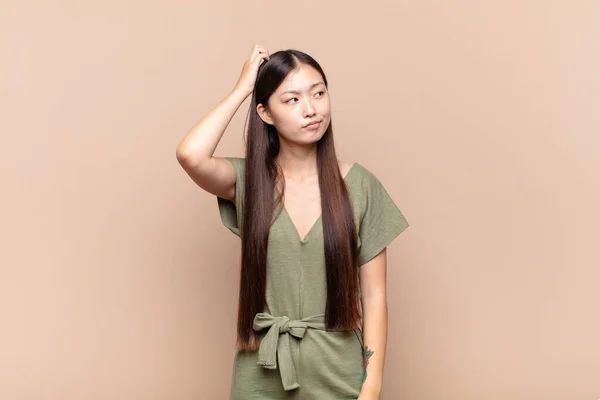 Asiática Jovem Mulher Sentindo Intrigado Confuso Coçando Cabeça Olhando Para — Fotografia de Stock