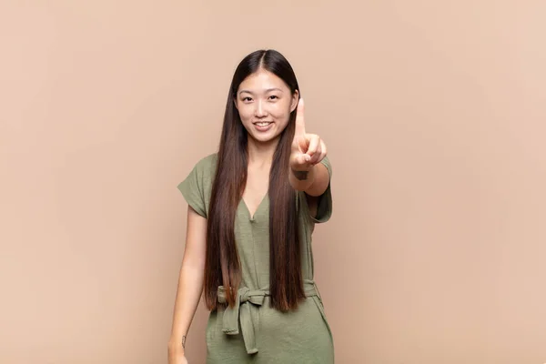Asiático Joven Mujer Sonriendo Buscando Amable Mostrando Número Uno Primero — Foto de Stock