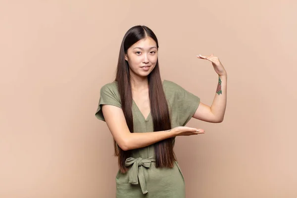 Asiática Jovem Segurando Objeto Com Ambas Mãos Espaço Cópia Lateral — Fotografia de Stock