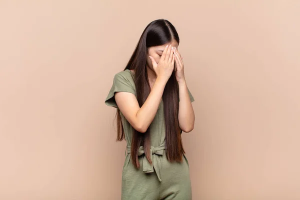 アジア系の若い女性が手で目を覆い絶望の悲しい不満そうな表情泣き側の景色で — ストック写真