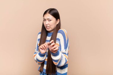 Asyalı genç bir kadın tiksinti ve mide bulantısı hissediyor. İğrenç, kokuşmuş ya da kokuşmuş bir şeyden uzak duruyor.