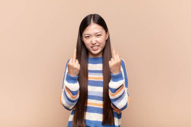 Asyalı genç kadın kışkırtıcı, agresif ve müstehcen hissediyor. İsyankar bir tavırla orta parmağını hareket ettiriyor.