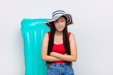 Asyalı genç bir kadın endişeli, hasta, hasta ve mutsuz hissediyor. Ağrılı bir mide ağrısı veya grip geçiriyor. yaz konsepti