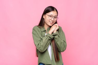 Asyalı genç bir kadın aşık ve sevimli görünüyor. Sevimli ve mutlu. Romantik bir şekilde gülümsüyor.