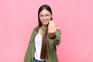 Asyalı genç kadın kendini mutlu, başarılı ve kendinden emin hissediyor, bir meydan okumayla karşı karşıya ve 