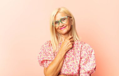 Orta yaşlı kadın son derece mutlu ve şaşırmış görünüyor, başarıyı kutluyor, bağırıyor ve zıplıyor.