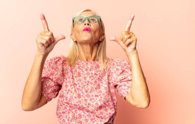 Orta yaşlı kadın profili, mutlu ve heyecanlı görünüyor, bağırıyor ve kenarda yer kopyalamak için arıyor.