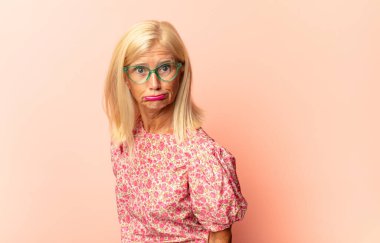 Orta yaşlı kadın korkmuş ve şok olmuş hissediyor, ağzı açık şaşkınlık içinde.