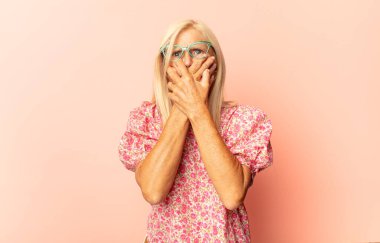 Orta yaşlı bir kadın üzgün, hayal kırıklığına uğramış bir bakışla gözlerini kapatıyor. Ağlıyor, yan gözle bakıyor.