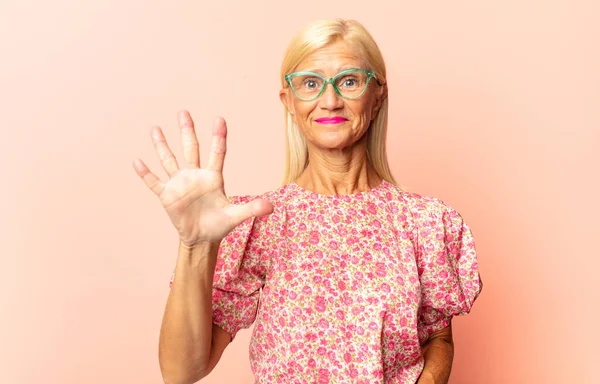 Vrouw Van Middelbare Leeftijd Lacht Ziet Vriendelijk Uit Toont Nummer — Stockfoto