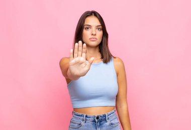 Genç ve güzel bir kadın ciddi, sert, hoşnutsuz ve kızgın görünüyor.