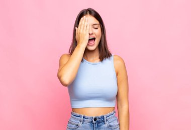 Genç ve güzel bir kadın uykulu görünüyor, sıkılmış ve esniyor, baş ağrısı ve yüzünün yarısını kaplayan bir eliyle