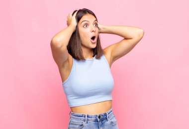 Genç ve güzel bir kadın, ağzı açık, korkunç ve şok olmuş görünüyor, korkunç bir hata yüzünden, el ele tutuşuyor.