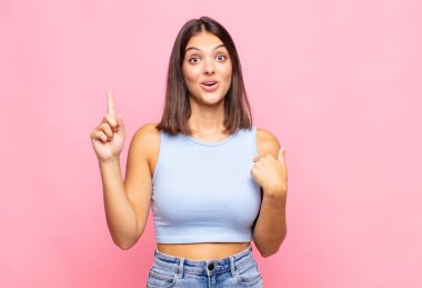 Genç ve güzel bir kadın gururlu ve şaşırmış hissediyor. Kendine güvenerek kendini bir numara gibi hissediyor.