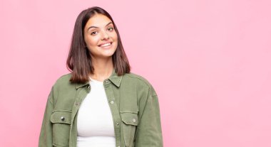 Genç ve güzel bir kadın mutlu ve hoş bir şekilde şaşırmış görünüyor. Büyülenmiş ve şok olmuş bir ifadeyle heyecanlanıyor.