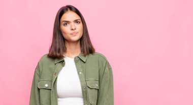 Genç ve güzel bir kadın kafası karışık ve kuşkulu, merak ediyor ya da karar vermeye çalışıyor.