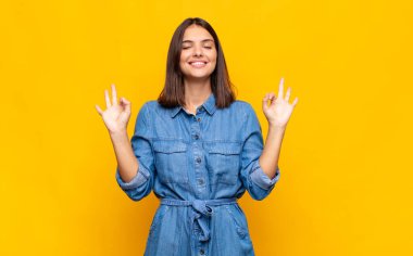 Genç ve güzel bir kadın konsantre olmuş ve meditasyon yapıyor, tatmin olmuş ve rahatlamış hissediyor, düşünüyor ya da bir seçim yapıyor.