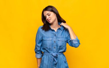 Genç, güzel bir kadın stresli, endişeli, yorgun ve hayal kırıklığına uğramış, gömleğini çekiştirmiş, sorunlu görünüyor.