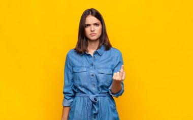 Genç ve güzel bir kadın kızgın, sinirli, isyankar ve agresif hissediyor, orta parmağını sallıyor, karşı koyuyor.