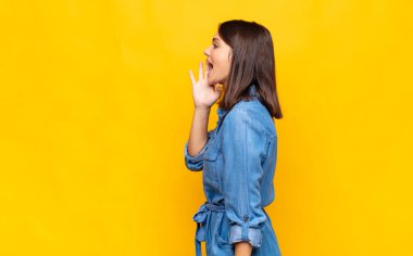 Genç ve güzel bir kadın profili, mutlu ve heyecanlı görünüyor, bağırıyor ve kenardaki boşluğu kopyalamak için arıyor.