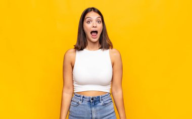 Genç ve güzel bir kadın korkmuş ve şok olmuş hissediyor, ağzı açık bir şekilde şaşkınlık içinde.
