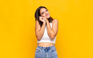 Genç, güzel bir kadın aşık ve sevimli görünüyor. Sevimli ve mutlu. Romantik bir şekilde gülümsüyor.