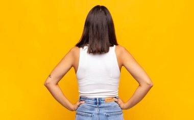 Genç, güzel bir kadın, kafası karışık ya da dolu ya da şüphe ve soru dolu, merak ediyor, elleri kalçasında, dikiz aynasından.