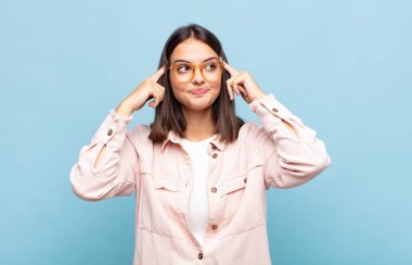 Genç ve güzel bir kadın kafası karışık ya da şüpheci, bir fikre odaklanmış, çok düşünüyor, kenarda boşluğu kopyalamak istiyor.