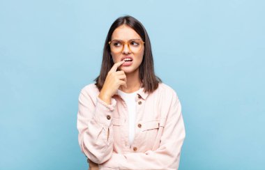 Şaşırmış, gergin, endişeli ya da korkmuş bakışları olan genç, güzel bir kadın.