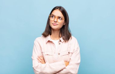 Endişeli, kafası karışık, budala bir ifadeyle genç, güzel bir kadın, kopya alanı arıyor, şüphe ediyor.