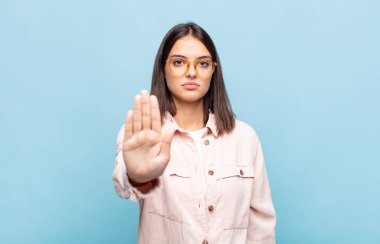 Genç ve güzel bir kadın ciddi, sert, hoşnutsuz ve kızgın görünüyor.