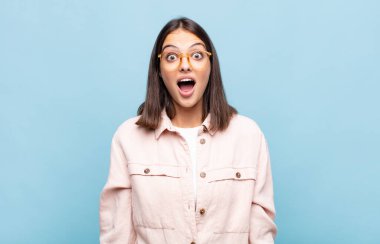 Genç ve güzel bir kadın şok olmuş ya da şaşırmış görünüyor, ağzı açık bir şekilde 