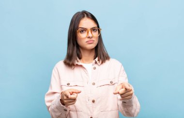 Genç ve güzel bir kadın kameraya iki parmağıyla ve kızgın bir ifadeyle sana görevini yapmanı söylüyor.