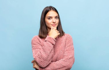 Genç, güzel bir kadın ciddi görünüyor, kafası karışık, kararsız ve düşünceli, seçenekler ve seçimler arasında şüpheci.