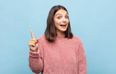 Genç ve güzel bir kadın bir fikri fark ettikten sonra mutlu ve heyecanlı bir dahi gibi hissediyor. Neşeli bir şekilde parmağını kaldırıyor.!